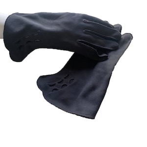 May include: A pair of black leather gloves with cut-out detailing. The gloves are folded in half and the fingers are curled.