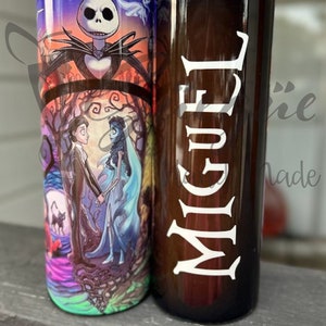 Puede incluir: Dos vasos de acero inoxidable. Uno presenta un dise&ntilde;o colorido con Jack Skellington y personajes de The Nightmare Before Christmas y Corpse Bride. El otro es marr&oacute;n con el nombre "Miguel" en blanco.