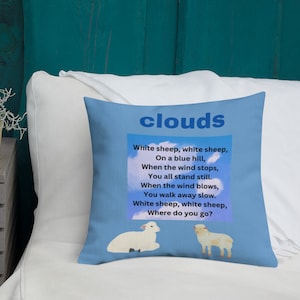 May include: A blue throw pillow with the word "clouds" printed in white. The pillow features a white sheep on a blue sky background with the text "White sheep, white sheep, On a blue hill, When the wind stops, You all stand still. When the wind blows, You walk away slow. White sheep, white sheep, Where do you go?"