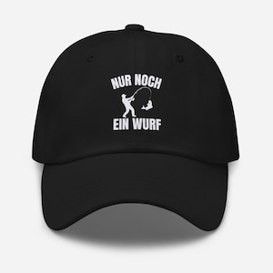 Könnte beinhalten: Eine schwarze Baseballkappe mit einem weißen Grafikdruck, der eine angelnde Person mit Rute und einen aus dem Wasser springenden Fisch zeigt. Der Text "NUR NOCH EIN WURF" ist in weißen Großbuchstaben über und unter dem Motiv gedruckt.