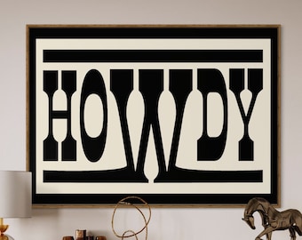 May include: A framed black and white print with the word "HOWDY" in bold letters. The print is hanging on a wall above a wooden cabinet with gold accents. There is a gold lamp on the left side of the cabinet and a gold metal side table with a white marble top on the right side of the cabinet.