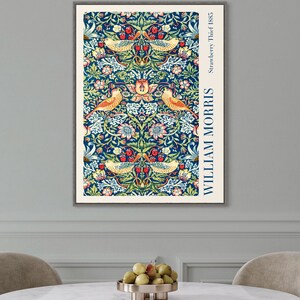 Puede incluir: Una impresi&oacute;n enmarcada de un patr&oacute;n floral vintage con p&aacute;jaros y bayas. La impresi&oacute;n es en tonos de azul, verde, amarillo, rojo y blanco. El texto "WILLIAM MORRIS" y "Strawberry Thief, 1885" est&aacute; impreso en el lado derecho de la impresi&oacute;n.