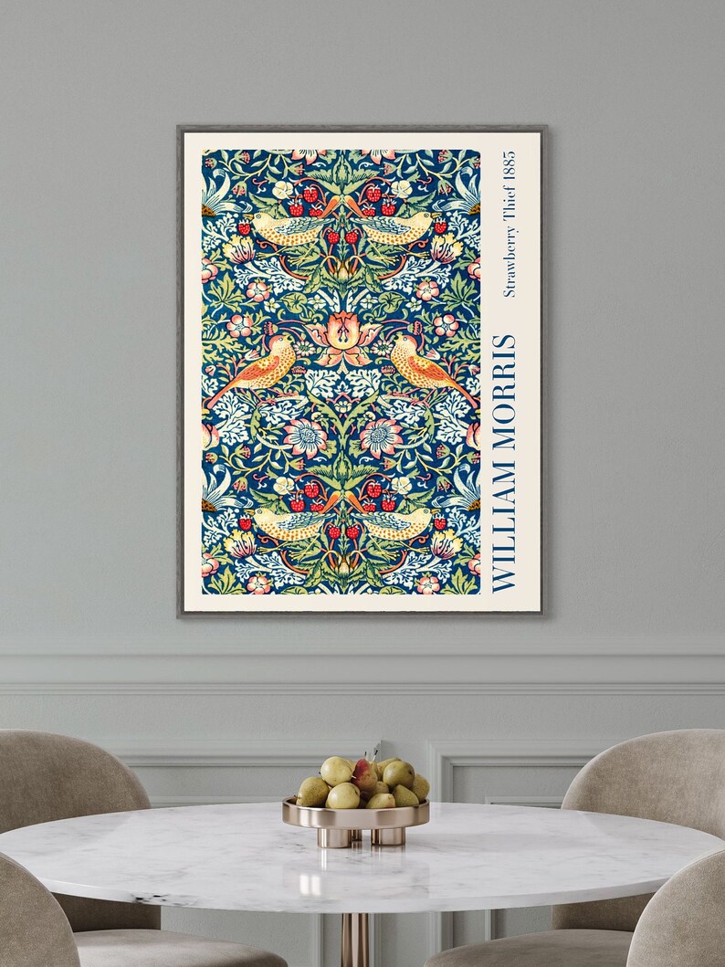 Puede incluir: Una impresi&oacute;n enmarcada de un patr&oacute;n floral vintage con p&aacute;jaros y bayas. La impresi&oacute;n es en tonos de azul, verde, amarillo, rojo y blanco. El texto "WILLIAM MORRIS" y "Strawberry Thief, 1885" est&aacute; impreso en el lado derecho de la impresi&oacute;n.