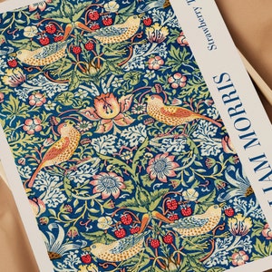 Puede incluir: Una tela de estampado floral de estilo vintage con un patr&oacute;n repetitivo de flores estilizadas, hojas y p&aacute;jaros en tonos rojos, naranjas, amarillos y verdes sobre un fondo azul. La tela est&aacute; etiquetada como "Strawberry Thief" y "William Morris".