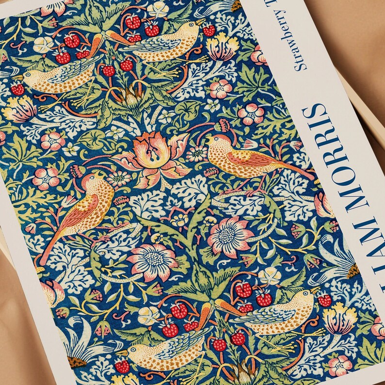 Puede incluir: Una tela de estampado floral de estilo vintage con un patr&oacute;n repetitivo de flores estilizadas, hojas y p&aacute;jaros en tonos rojos, naranjas, amarillos y verdes sobre un fondo azul. La tela est&aacute; etiquetada como "Strawberry Thief" y "William Morris".