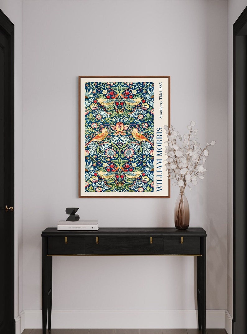 Puede incluir: Una impresi&oacute;n enmarcada de un patr&oacute;n floral vintage con p&aacute;jaros y bayas. La impresi&oacute;n se titula "Strawberry Thief" de William Morris y data de 1883.
