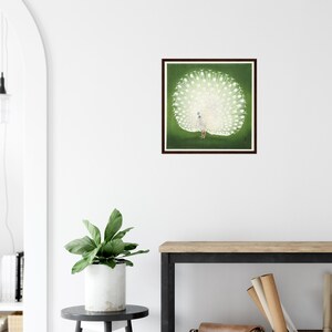 May include: A white peacock with its tail feathers spread out in a fan shape against a green background. The peacock is standing on a green surface. The image is framed in a dark brown frame.