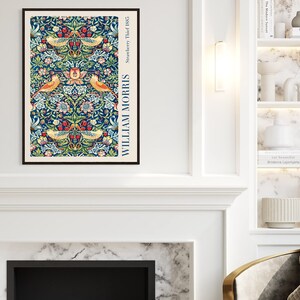 Puede incluir: Una impresi&oacute;n enmarcada de un dise&ntilde;o floral vintage con p&aacute;jaros y el texto "William Morris Strawberry Thief 1883" en blanco sobre fondo negro.