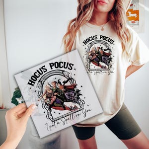 May include: A white t-shirt with a black graphic of the Sanderson sisters from the movie Hocus Pocus. The graphic includes the text "Hocus Pocus I put a spell on you".