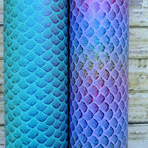 May include: Two rolls of iridescent mermaid scale fabric. One roll is a teal blue colour and the other is a lavender colour.