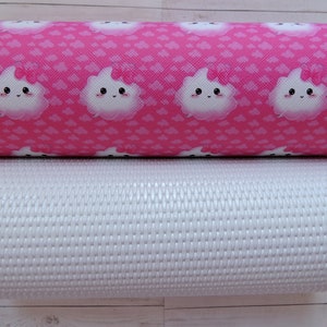 Peut inclure: Deux rouleaux de tissu, l'un rose avec un motif de nuage blanc et l'autre blanc avec une texture tissée.