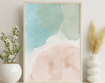 Puede incluir: Una pintura abstracta de acuarela enmarcada con tonos de azul, verde y rosa. La pintura se exhibe en un estante blanco con un jarrón de flores secas.