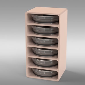 May include: A light peach-colored storage unit with five open shelves, each holding a circular, metallic object. The unit has rounded edges and a minimalist design. The objects appear to be containers or trays.