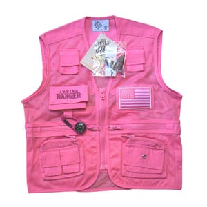 May include: Pink mesh utility vest with multiple pockets, a zipper closure, and a Junior Ranger patch. The vest also features a compass, a carabiner, and an American flag patch.