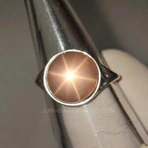 Könnte beinhalten: Ein silberner Ring mit einem pfirsichfarbenen Edelstein, der einen sechsstrahligen Stern zeigt. Der Ring hat ein schlichtes Band mit einem durchbrochenen Design an den Seiten. Der Etsy-Shop-Name "JLRADIANTGEMS.ETSY.COM" ist sichtbar.