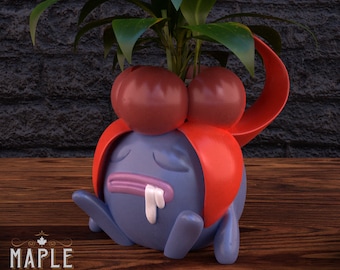 Puede incluir: Un macetero de color morado y rojo impreso en 3D con forma de personaje de Pokemon con una planta que crece en la parte superior. El macetero tiene una cara triste y un sombrero rojo. El texto "PATREON" es visible en la esquina inferior derecha de la imagen.