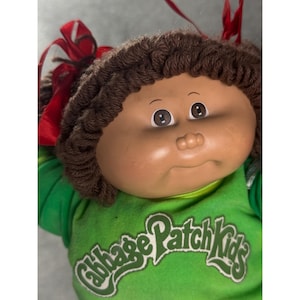Vintage Cabbage Patch Kids-pop uit 1982 van Coleco met bruin haar, ogen en groen shirt, 40 cm.
