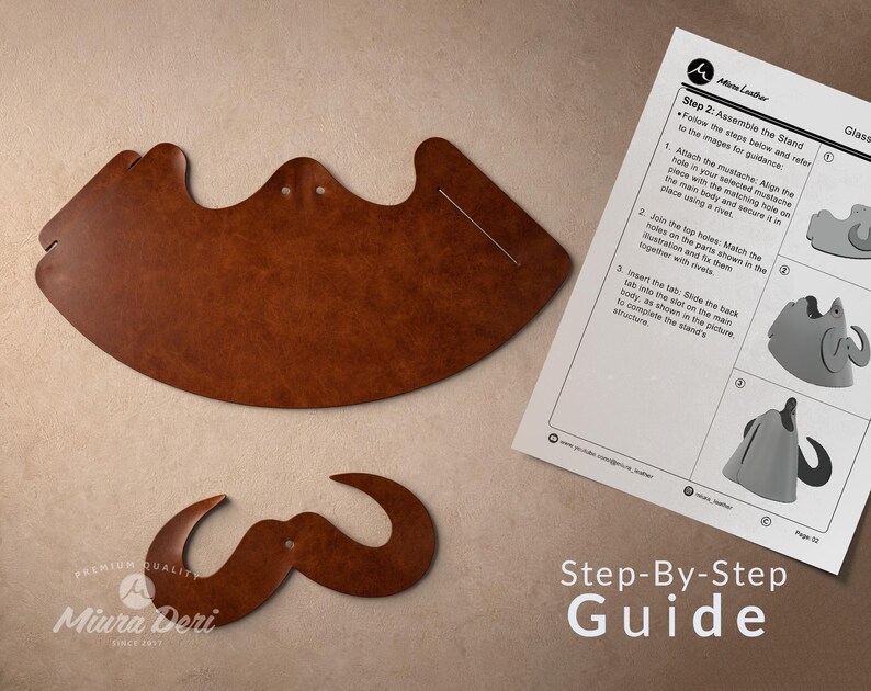 May include: Two pieces of brown leather, one large and curved, the other a mustache shape, with a step-by-step guide. The guide shows how to assemble the stand. The text on the guide says "Miura Deri" and "Step-By-Step Guide."