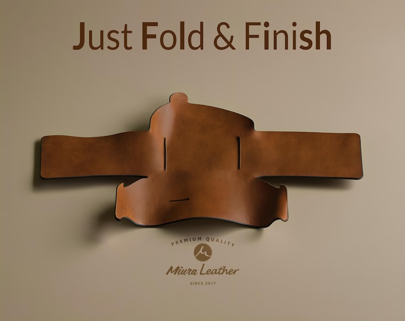 K&ouml;nnte beinhalten: Eine braune Ledergeldb&ouml;rse liegt flach und zeigt die Innenseite. Die Geldb&ouml;rse ist in der Mitte gefaltet und hat eine Klappe, die mit einem Druckknopf geschlossen wird. Der Text "Just Fold & Finish" ist oben im Bild gedruckt. Der Text "Premium Quality" und "Miura Leather" ist unten im Bild gedruckt.