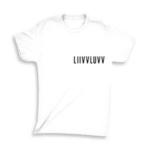 Puede incluir: Camiseta blanca con la palabra "LIIVVLUVV" impresa en negro. La camiseta está hecha de un material suave y ligero y tiene un diseño clásico de cuello redondo. Esta camiseta informal es perfecta para el uso diario.