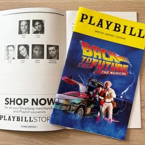 May include: A Playbill for the musical "Back to the Future" at the Winter Garden Theatre. The cover features a blue and black image of the DeLorean time machine and the main characters, Marty McFly and Doc Brown.