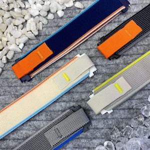 Könnte beinhalten: Fünf verschiedene Uhrenarmbänder in verschiedenen Farben und Materialien. Die Armbänder sind aus Nylon, Stoff und Leder.