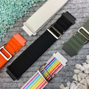 Könnte beinhalten: Fünf verschiedene Uhrenarmbänder in verschiedenen Farben und Materialien. Die Armbänder sind aus Nylon, Canvas und Leder. Die Armbänder sind alle in verschiedenen Farben, darunter Schwarz, Weiß, Orange, Grün und Regenbogen.
