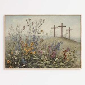 Op de afbeelding: Een schilderij van drie houten kruisen die op een grassige heuvel staan met een veld vol wilde bloemen op de voorgrond. De kruisen zijn bruin en de bloemen zijn in verschillende kleuren, waaronder geel, roze, blauw en wit.