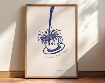 May include: A framed art print featuring a blue ink drawing of a cup overflowing with liquid. The words "my cup overflows" and "psalm 23:5" are written below the cup. The artwork is set against a cream-colored background.