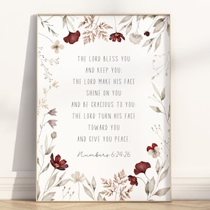 May include: A printable wall art design featuring a watercolour illustration of flowers and leaves in shades of brown, red, and white. The design includes a quote from the Bible, Numbers 6:24-26, which reads: "The Lord bless you and keep you: The Lord make his face shine on you and be gracious to you: The Lord turn his face toward you and give you peace."