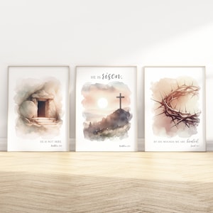 May include: Three watercolor prints with Christian themes. The first print shows a stone tomb with an open door and the text "He is not here." The second print shows a cross on a hill with a sunrise in the background and the text "He is risen." The third print shows a crown of thorns with the text "By His wounds we are healed."