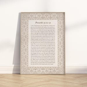 Puede incluir: Una impresión enmarcada con el texto "Proverbios 31:10-31" en una fuente decorativa. El texto es un pasaje de la Biblia, sobre un fondo beige con un borde adornado. El marco es de color beige claro.