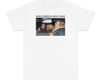 May include: White t-shirt with the phrase "MAKE AMERICA GREAT AGAIN" printed in black. The shirt features a photograph of three women in a car. The women are in a car, and the image is centered on the shirt.
