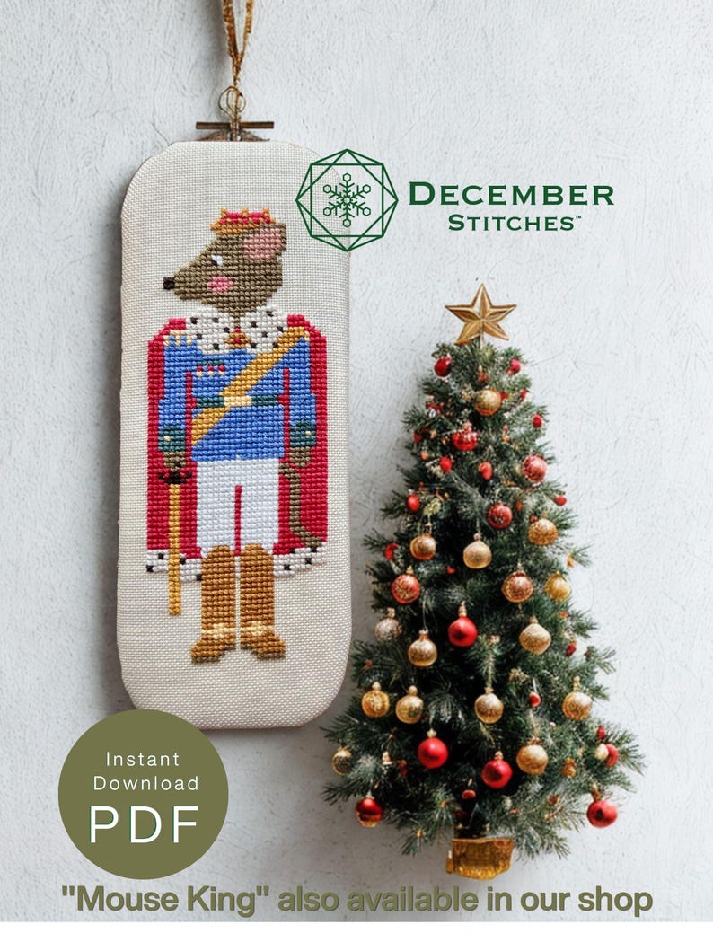 May include: A cross-stitch pattern featuring a mouse dressed as a king in a blue uniform, red cape, and gold crown. The design includes the text DECEMBER STITCHES, Instant Download PDF, and Mouse King also available in our shop. A small Christmas tree with red and gold ornaments stands beside the pattern.