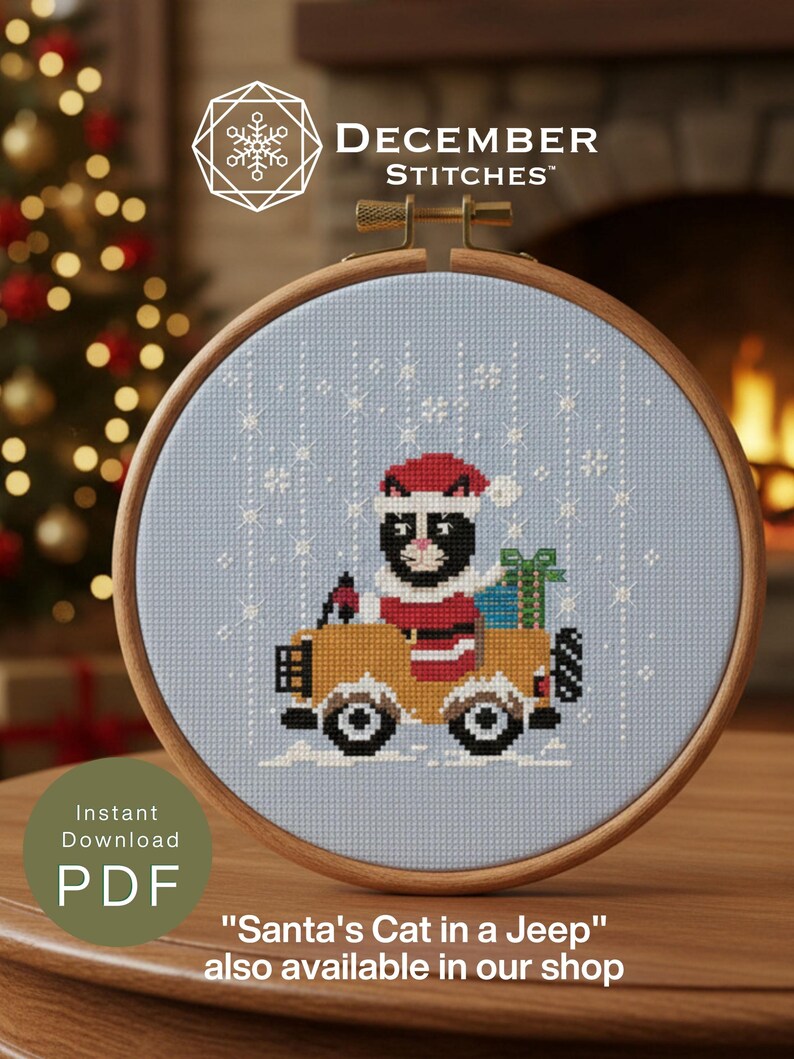 May include: A cross-stitch pattern in a wooden hoop featuring a black and white cat wearing a red Santa hat and coat, driving a yellow jeep with a green gift box in the back. The light blue fabric background includes white stitched snowflakes.