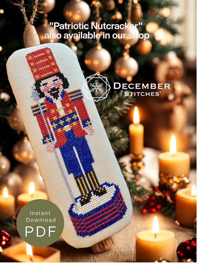 May include: A cross-stitch pattern of a nutcracker wearing a red and blue uniform with gold accents, standing on a red and blue base. The text reads "Patriotic Nutcracker" also available in our shop, DECEMBER STITCHES, and Instant Download PDF.