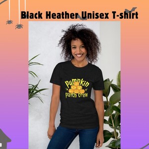 Pode incluir: Camiseta unissex preta mesclada com a frase "pumpkin patch crew" em amarelo. A camiseta apresenta um gráfico de abóboras. A pessoa na imagem está usando jeans azuis.