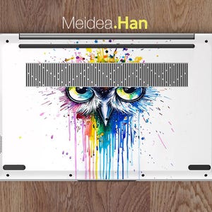 Pu&ograve; includere: Custodia bianca per laptop con un colorato design di gufo ad acquerello. Il gufo ha occhi blu e gialli brillanti, con un arcobaleno di colori che gocciolano. Il testo "Meidea.Han" &egrave; in alto.