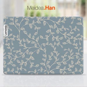 May include: A Lenovo laptop cover with a light blue background and a cream-colored, swirling leaf and vine pattern. The Lenovo logo is visible on the left side. The text "Meidea.Han" is in the top right corner.