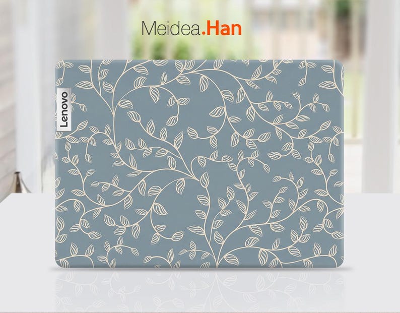 May include: A Lenovo laptop cover with a light blue background and a cream-colored, swirling leaf and vine pattern. The Lenovo logo is visible on the left side. The text "Meidea.Han" is in the top right corner.