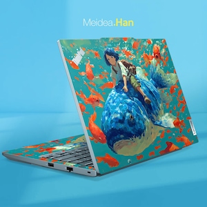 Peut inclure: Un ordinateur portable argenté avec une peau personnalisée. La peau présente une illustration d'une personne chevauchant une baleine bleue, entourée de poissons orange. Le texte "Meidea.Han" est en haut.