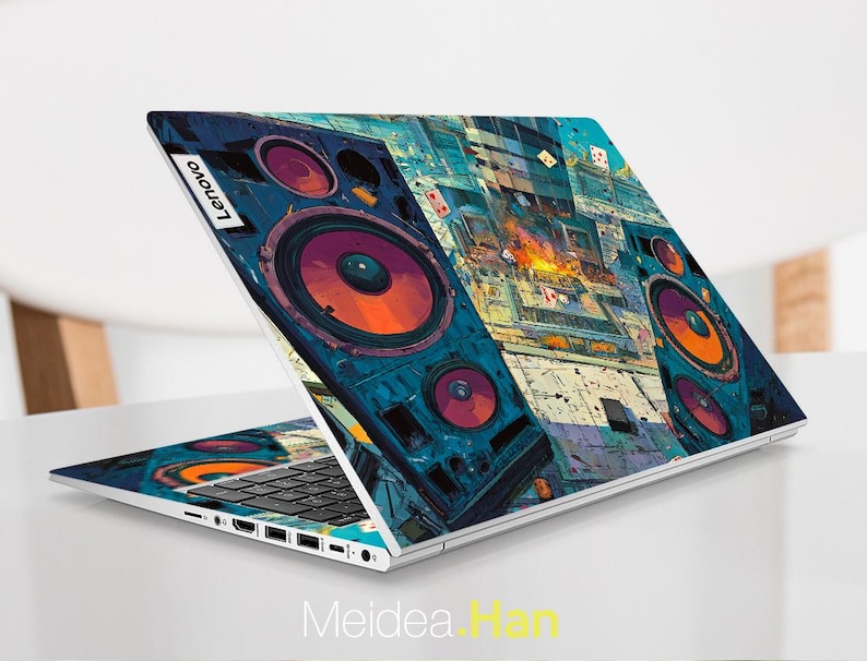 May include: A Lenovo laptop with a colourful, artistic design featuring large speaker graphics in shades of blue, orange, and purple. The laptop is open, displaying the keyboard and screen, with the Lenovo logo visible. The design covers the entire lid.