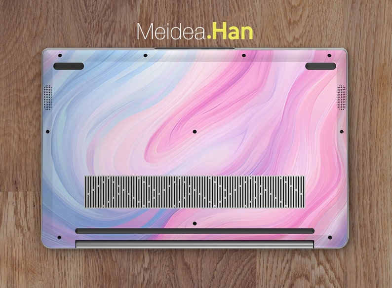 May include: The back of a laptop with a pink and blue marbled design. The laptop has a silver finish and a black speaker grill.