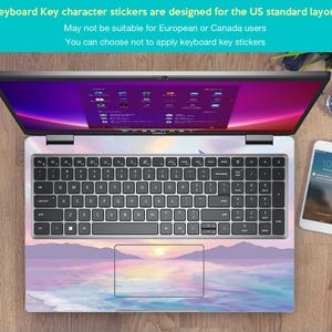 Pu&ograve; includere: Un computer portatile con un adesivo per tastiera che raffigura un tramonto su uno specchio d'acqua. L'adesivo &egrave; progettato per i layout di tastiera standard degli Stati Uniti. Il testo sull'immagine recita: "Keyboard Key character stickers are designed for the US standard layout. May not be suitable for European or Canada users. You can choose not to apply keyboard key stickers."