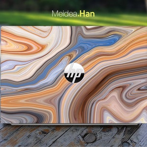 May include: A laptop computer with a colourful abstract marble design skin. The skin features swirling patterns of brown, orange, blue, and grey. The HP logo is visible on the laptop.