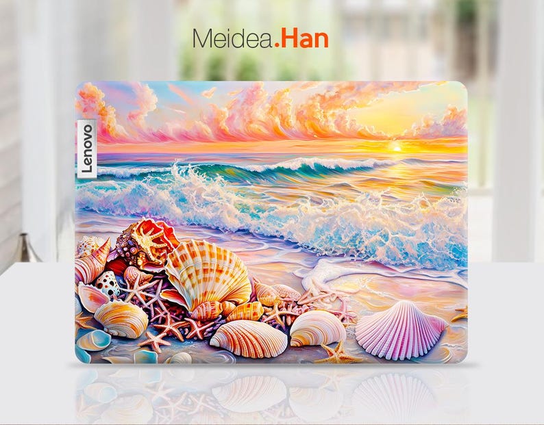 Op de afbeelding: Een kleurrijke laptop-skin met een schelpdesign op een achtergrond met zonsondergang en oceaan golven. Het ontwerp bevat een verscheidenheid aan schelpen in tinten roze, wit en bruin. De tekst "Lenovo" is zichtbaar aan de linkerkant van de skin.
