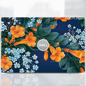 May include: A Dell laptop skin featuring a dark blue background with a vibrant floral pattern of bright orange trumpet-shaped flowers and clusters of small light blue blossoms nestled among dark green leaves. The Dell logo is centered on the lid.