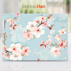 May include: A light blue laptop skin with a floral design featuring pink and white cherry blossoms. The skin has the word "Lenovo" printed on the left side.
