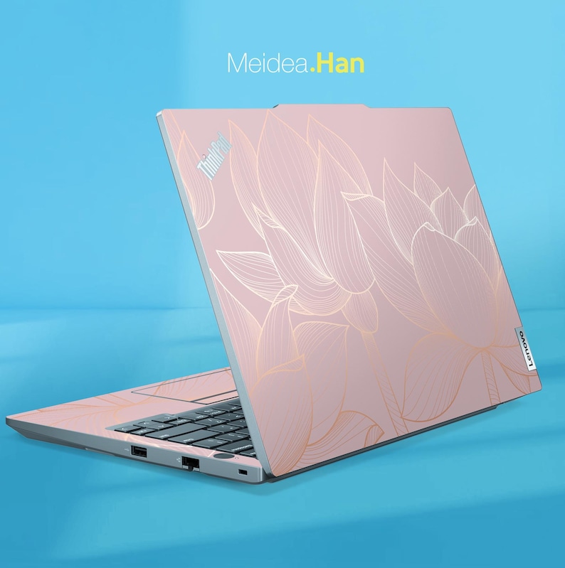 May include: Pink Lenovo ThinkPad laptop with a gold floral design. The laptop is open, displaying the keyboard and screen. The text "Meidea.Han" is in the upper left corner.
