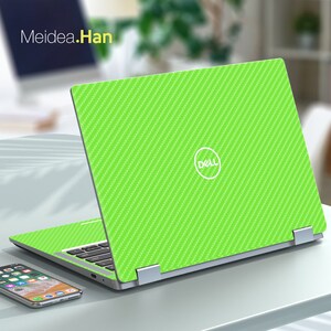 May include: A green laptop with a carbon fiber pattern on the lid. The laptop is open and the Dell logo is visible on the lid.
